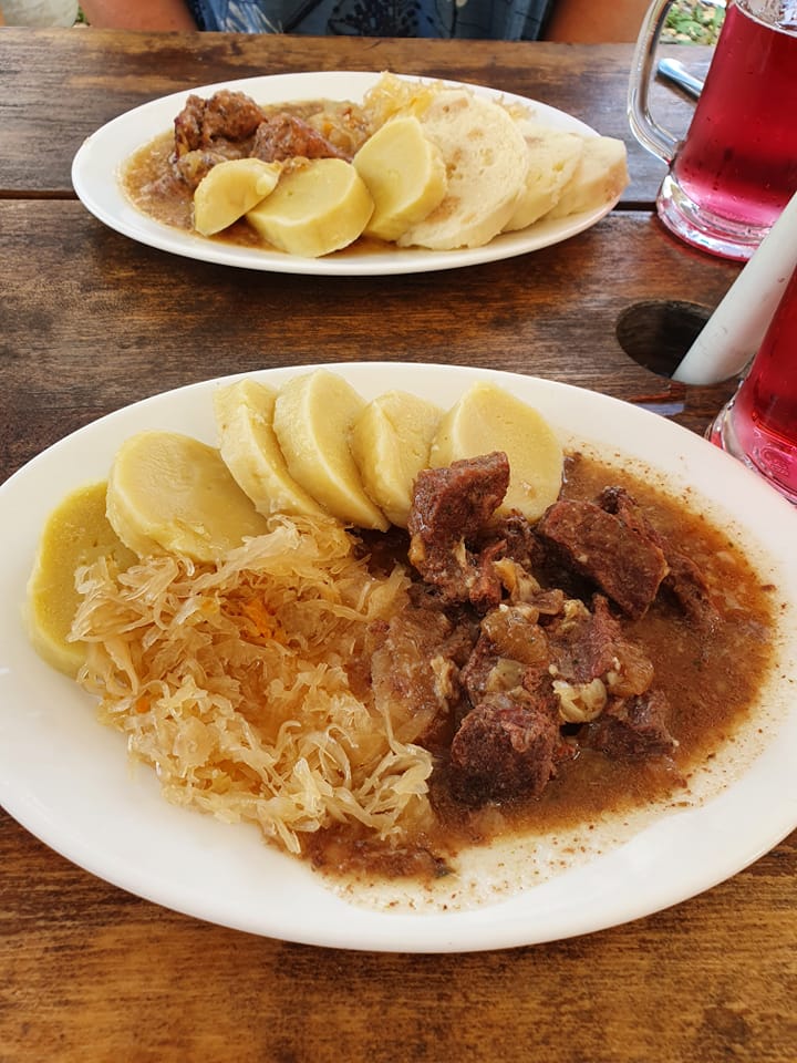 Maso s knedlíkem a zelím podávané u stolu